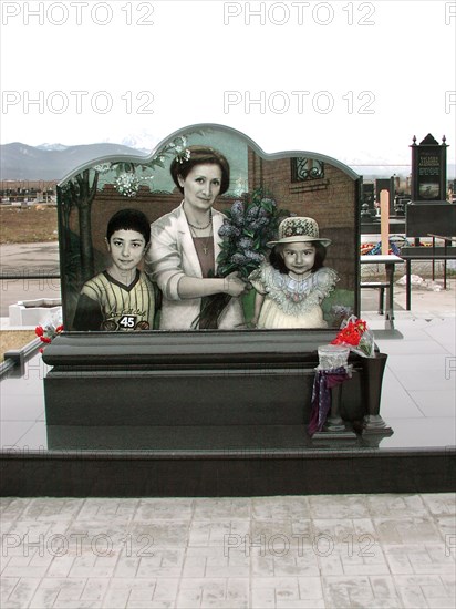 The tombstone with portraits of family members of construction engineer vitaly kaloyev - wife svetlana (c), daughter diana (r) and son kostya, kaloyev is suspected of the murder of a swiss air traffic controller peter nielsen, north ossetia, russia, february 27 2004.