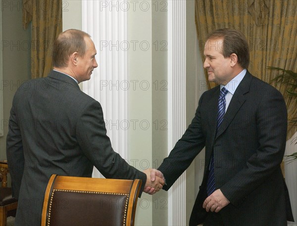 Russian president vladimir putin (l) and viktor medvedchuk, chief of staff of the ukrainian president shake hands prior to the talks, moscow, russia, april 16 2004.