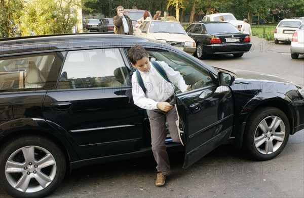 A schoolboy from a wealthy family arrives at moscow school 1230 on kutuzovsky prospect on sept, 1 when a new school year begins, moscow, russia, sptember 1 2005.