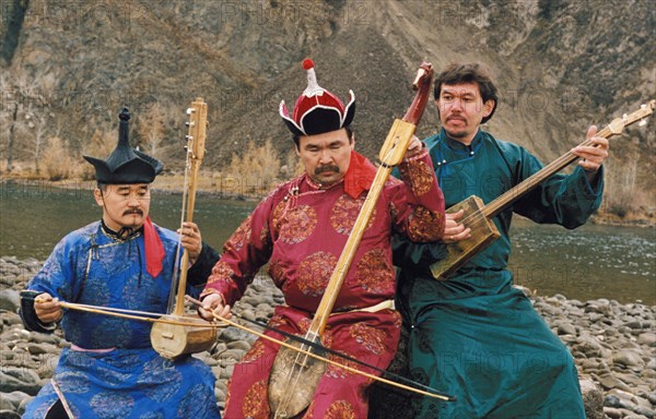 Members of the tuvan folk group, hun-huur-tu, performing by a river, tuva, russia.