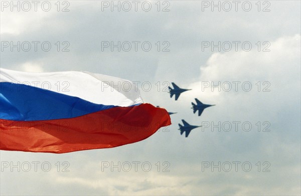 Su-27 fighter jet planes flying in formation with the flag of the russian federation in the foreground during the maks international air show, moscow region, august, 2001.