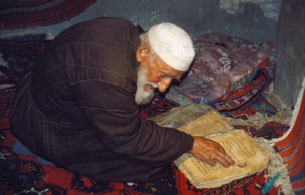 An old islamic man praying in a mosque in daghestan, russia.