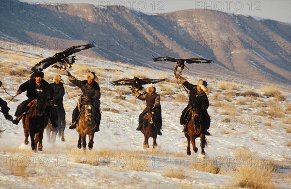 Kazakh hunters hunting on horseback with golden eagles, kazakhstan, november 1999.