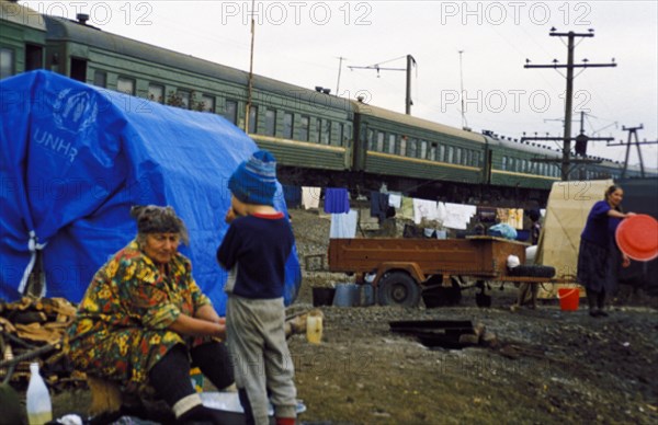 Chechen refugees outside the train they live in at the sleptsovskaya railway terminal, ingushetia, russia, november 1999.