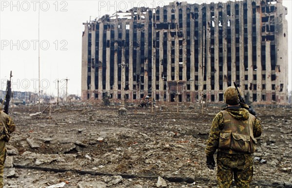 A russian interior ministry soldier looking at the ruins of the presidential palace in grozny, chechnya which was destroyed by russian shelling, february 1995.