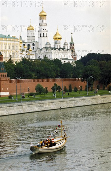 Old russian boat carrying a shrine with the relic of saint warrior admiral fyodor ushakov down the moskva river from the cathedral of christ the savior to kolomenskoye, august 11, 2002, the moscow kremlin is in the background.