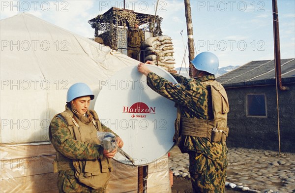 Russian un peacekeepers in abkhazia adjusting a satellite dish at their camp during the conflict between georgia and abkhazia, february 2003.