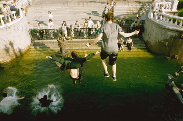 Young people swimming in the fountain in manege square to cool off from the heat, moscow, russia, july 2003.