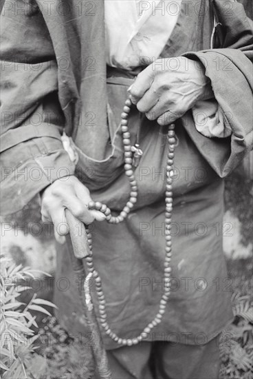 Buddhist man chanting on beads, Darjeeling, West Bengal, India