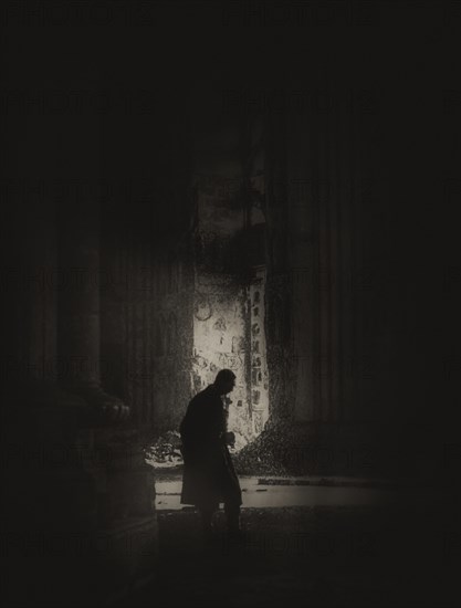 A magic lantern slide shows a silhouetted man stands inside the Cathedral of Reims after the shelling by German troops in 1914; Reims