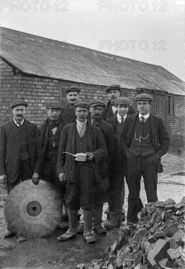 A historical image of a group of men standing together in suits and hats