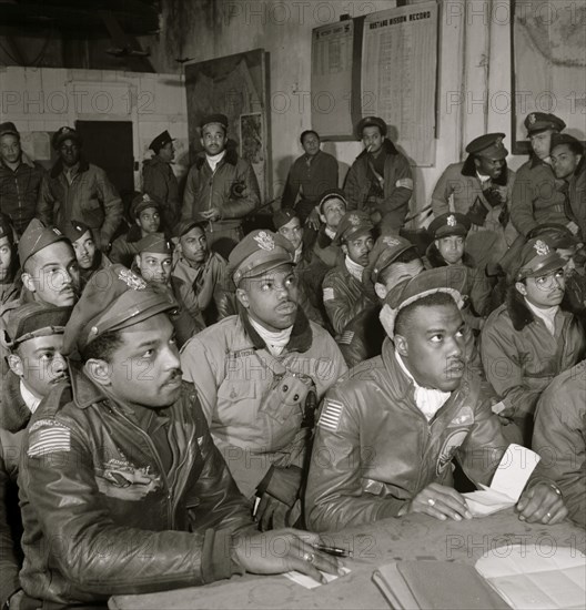 Several Tuskegee airmen attending a briefing in Ramitelli, Italy, March 1945