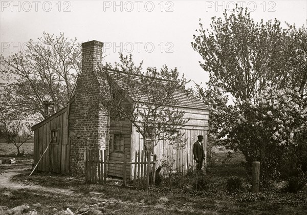 African American man in front of small house