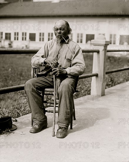 Ex-Slave - Man seated with pipe in 1920