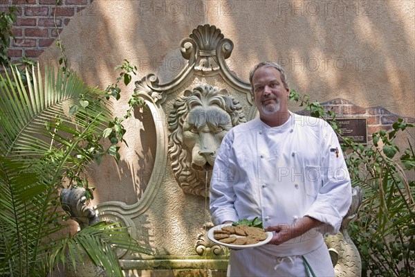 Chef  holds a plate of Fried Green Tomatoes