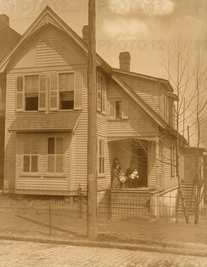 African American family posed on porch of house