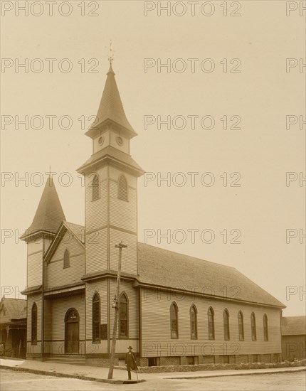 African American man standing on sidewalk in front of church
