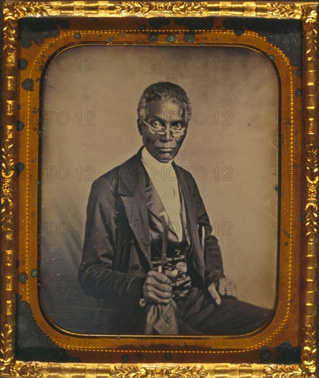 Philip Coker, three-quarter length portrait, full face, seated, wearing spectacles