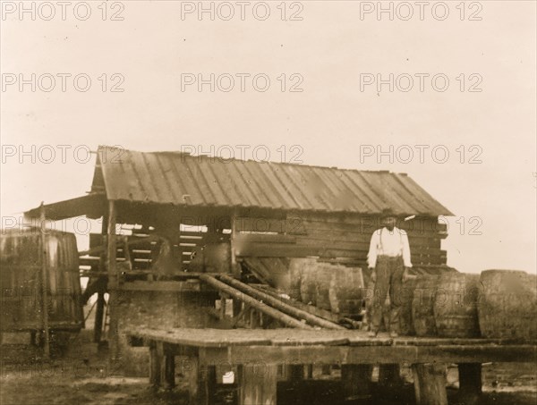 African American man standing unloading dock with large barrels