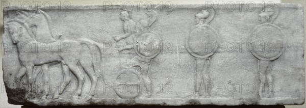 Base of funerary Kouros. Four-horse chariot and hoplites.