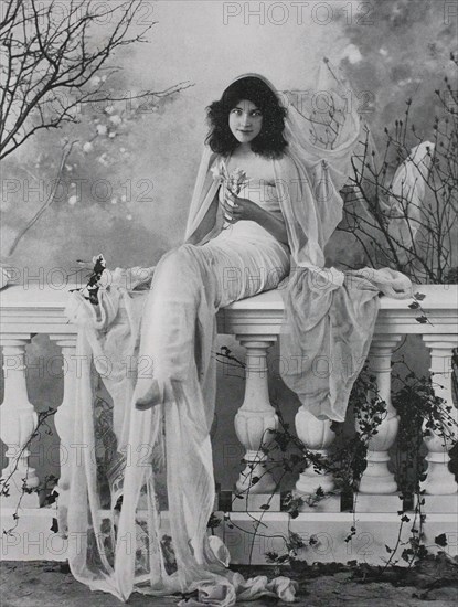 beautiful woman with veil sits on a balustrade on the terrace