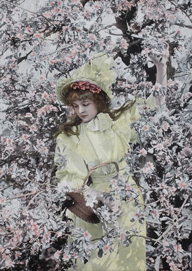 Girl is standing under a tree in full bloom