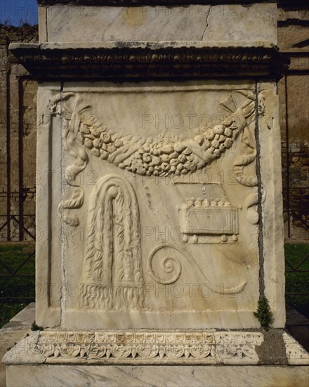 South side depicting a garland of flowers, a chest for incense, the curved cane of the augur and a tablecloth.