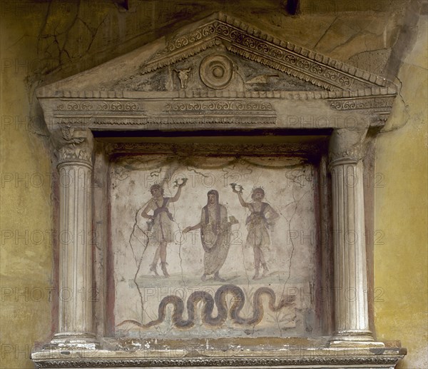 Fresco depicting two Lares flanking a genius. The snake, associated with the prosperity, approaches an altar.