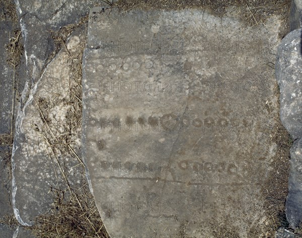 Roman games engraved into seats of the stadium, upper bleachers.