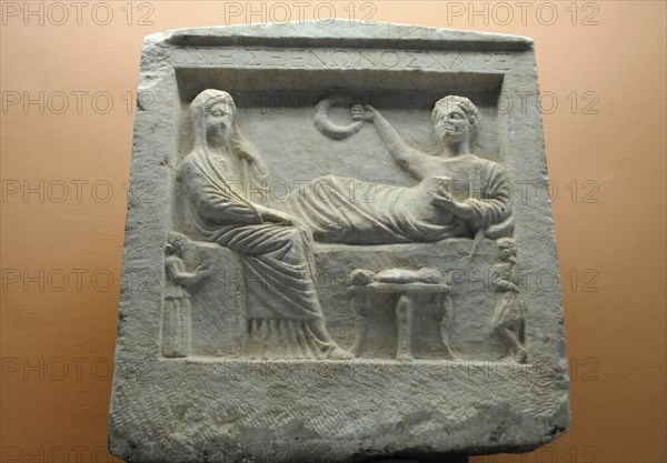 Tombstone. 'Parting scene' in relief.