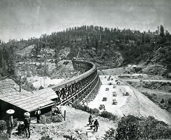 1877 - In its eagerness to push toward Utah in its race with the westward building Union Pacific, Central Pacific Railroad bridged many of the High Sierra chasms with timber trestles. This remarkable photo was taken at Secrettown Trestle, 62 miles from Sacramento on the western slope of the Sierras in 1877.