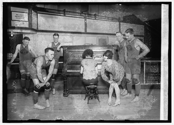 1926 - Miss Vivian Marinelli giving Charleston dancing lessons to basketball players of the Palace Club, the Washington, D.C., entry in the American basketball league. Left to right: Kearns, Manager Kennedy, Conway, woman playing piano, Miss Marinelli, Grody, and Saunders.