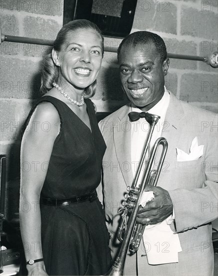 Louis 'Satchmo' Armstrong plays his trumpet in front of a Voice of American microphone. Armstrong is a leading good will ambassador through his music. Washington, DC, 1960.