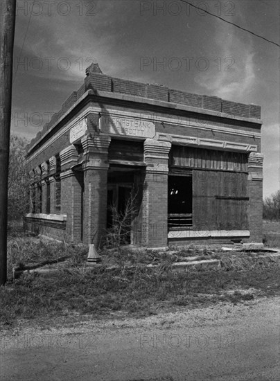 Black and white photo of abandoned bank in the ghost town of Truscott Texas circa 1990s .