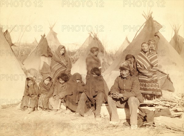 Group of eleven Miniconjou (children and adults) in a tipi camp, probably on or near Pine Ridge Reservation. 1891.