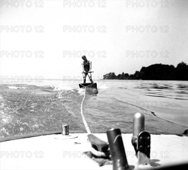 Man skiing behind a boat on a board circa 1930s.