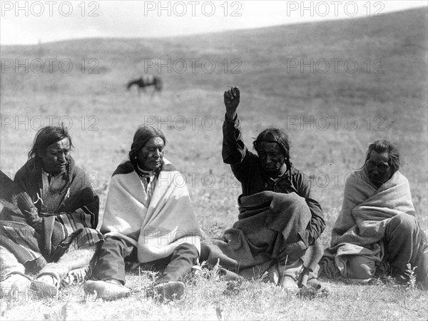 Edward S. Curtis Native American Indians - Four Atsina men, one with arm and fist raised skyward, one holding a wing circa 1908.