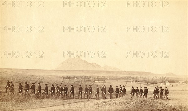 Company 'C,' 3rd U.S. Infantry, caught on the fly, near Fort Meade. Bear Butte in the distance 1890.