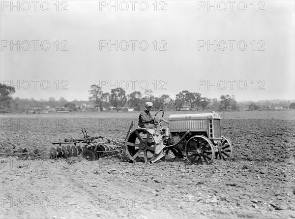 Farmer driving Ford Tractor in field circa 1917.