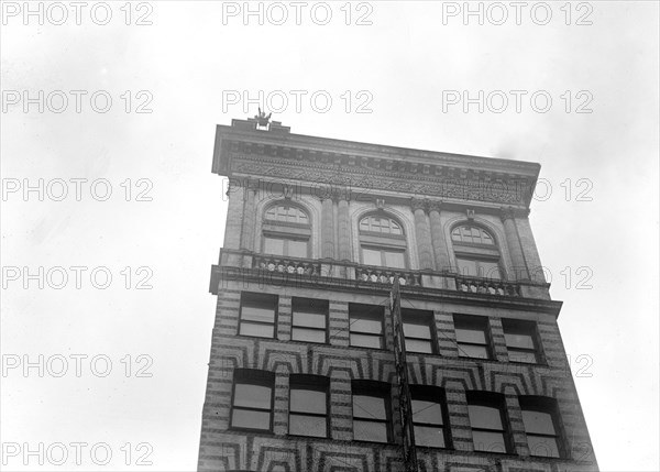 J. Reynolds Acrobat, performing acrobatic and balancing acts on top of building above 9th Street NW in Washington D.C. circa 1917.