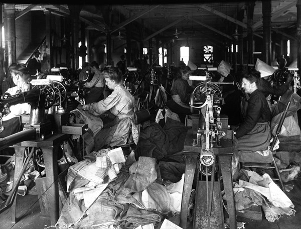 Woman repairing mailbags at United States Post Office circa early 1900s .