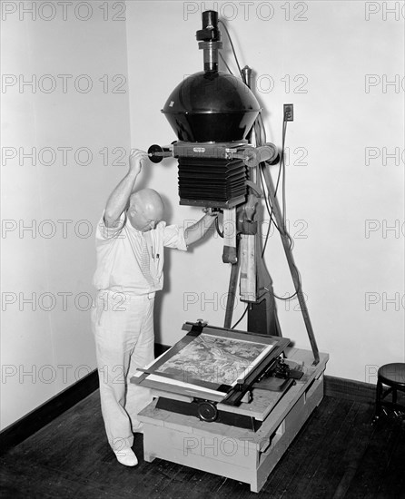 Map making - photographer making prints of a map circa 1937 .