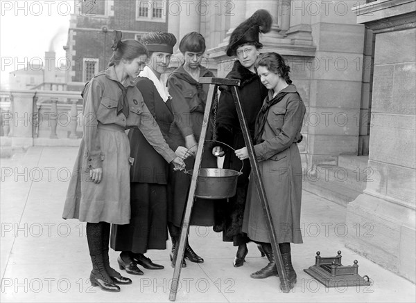 Girl Scouts in 1918 putting money into a kettle (Mrs. Morgan rear right) .