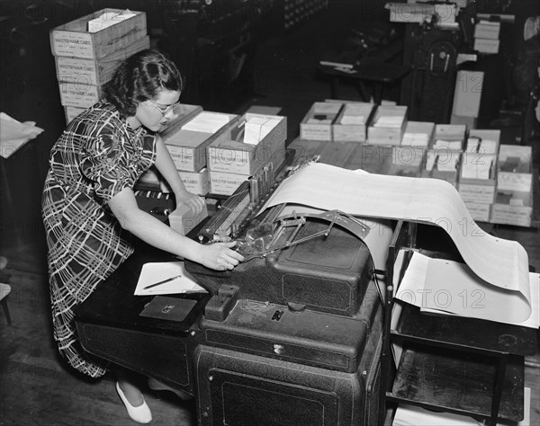 Social Security Board Records Office - working at machine listing numbers on loose leaf ledger .