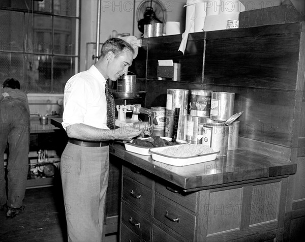 Government worker at Treasury Department testing food circa 1937 .