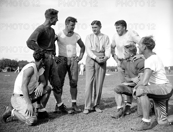 George Marshall, owner of the Washington Redskins, talks with some of his players, left to right: Wayne Millner, Charlie Malone, Vic Carroll, George Marshall, Bill Young, Ed Michaels, Jim Garber circa 1937  .