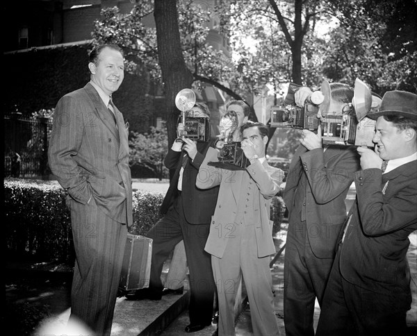 News photographers taking picture of Jimmy Mattern, noted flyer, leaving the Soviet Embassy today after reporting on his search for the six Russian Polar Flyers lost far above the Arctic Circle circa 1937.