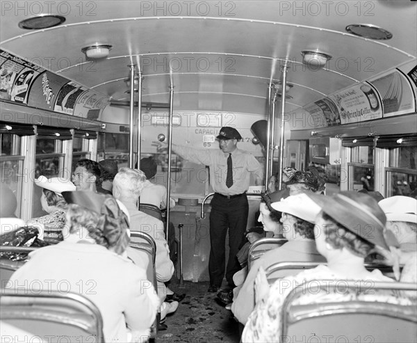 People riding a sightseeing bus circa 1937 .