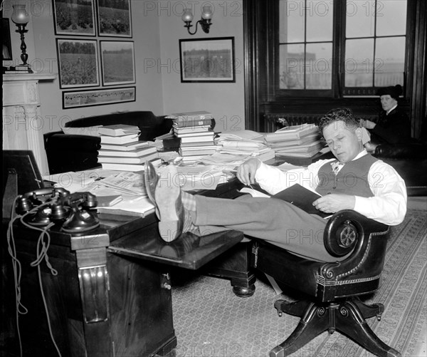1/26/1938 - Democrat Senator Allen J. Ellender, of Louisiana, rests and studies up on Senate procedure of filibuster while his colleagues continue the Filibuster against the anti-lynching bill circa 1938.