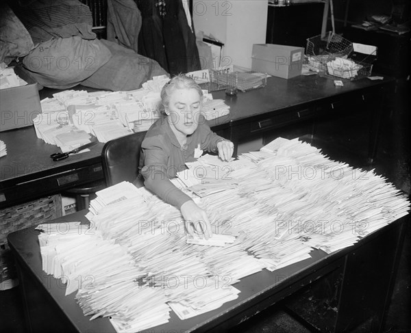 January 28, 1938 - Miss Margaret Lehand, Personal Secretary to President Roosevelt, is shown opening some of the 30,000 letters with donated dimes to the infantile paralysis foundation to arrive in the mail .